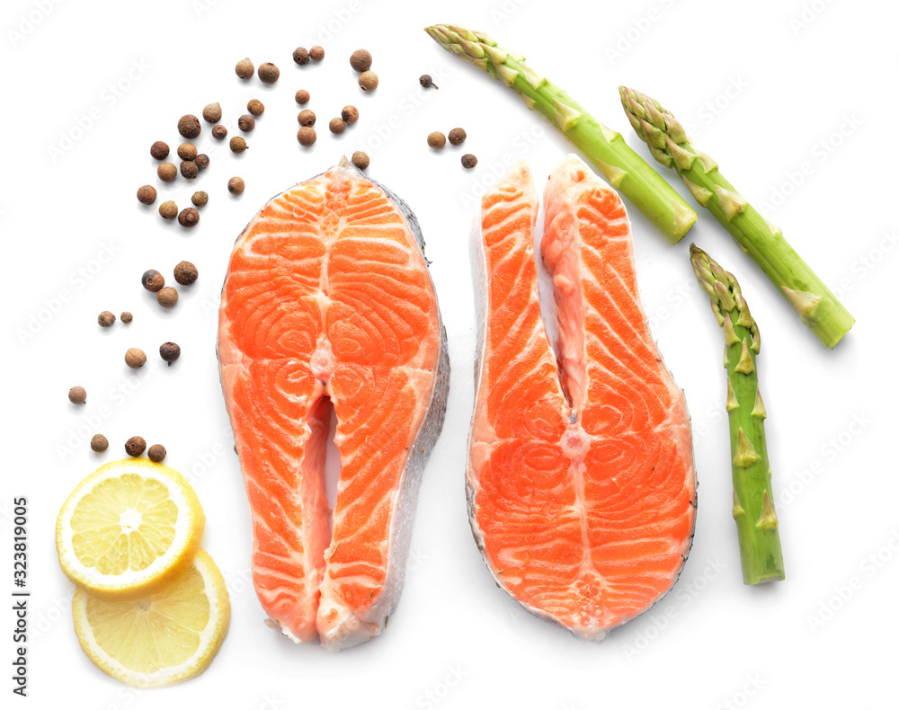 Raw salmon steaks and spices on white background