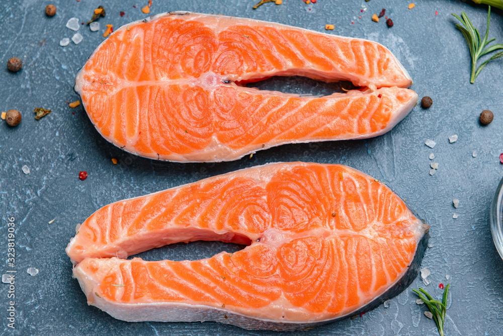 Raw salmon steaks on table