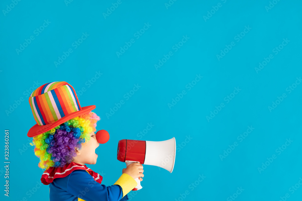 Funny kid clown shouting by megaphone