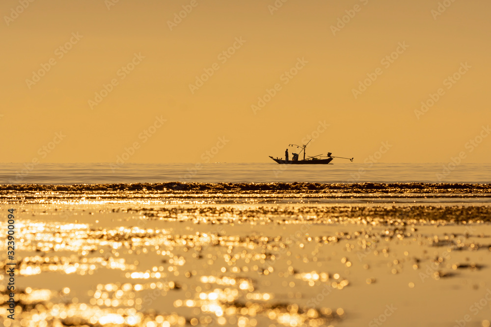 Local fishermen are catching fish in the sea in the morning on a small fishing boat.