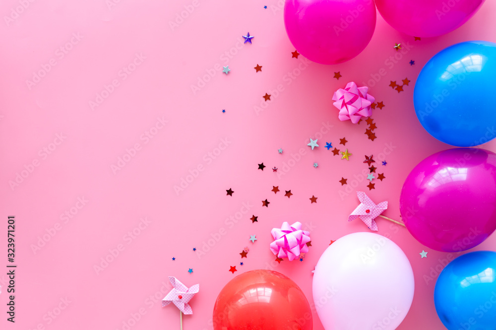 Party concept. Colorful balloons and confetti on pink background top-down frame copy space