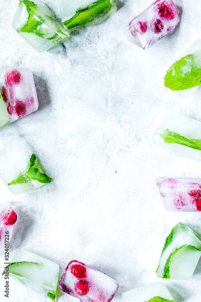 frozen red berries in ice cubes on stone background space for text top view