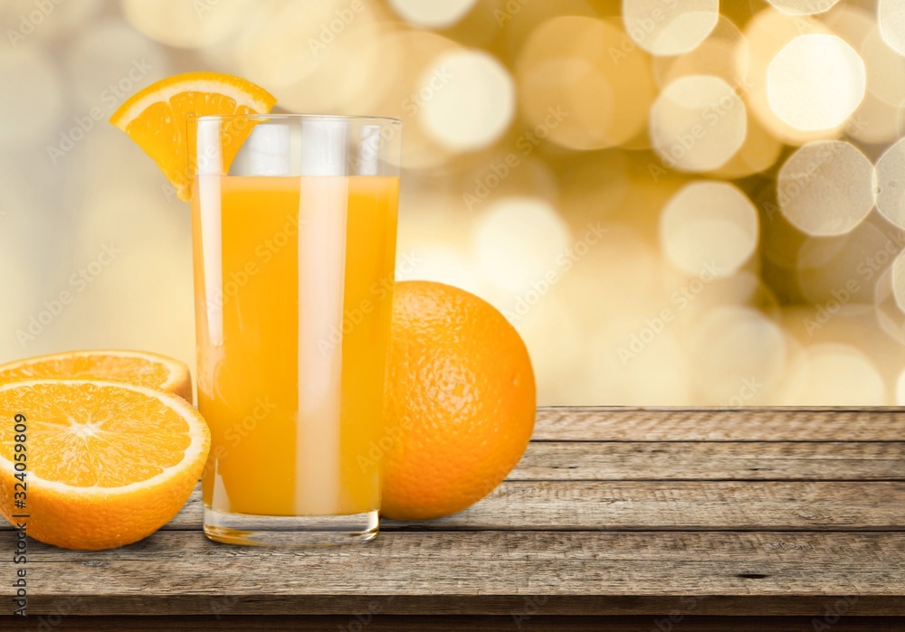 Orange juice in glass and slices of orange fruit on the desk