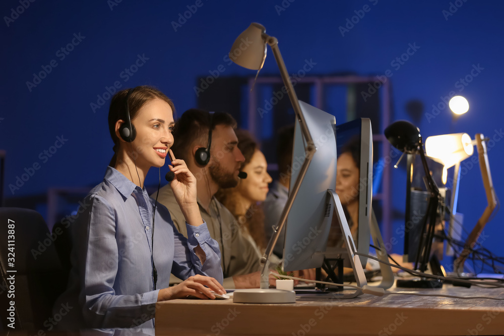 Technical support agents working in office at night