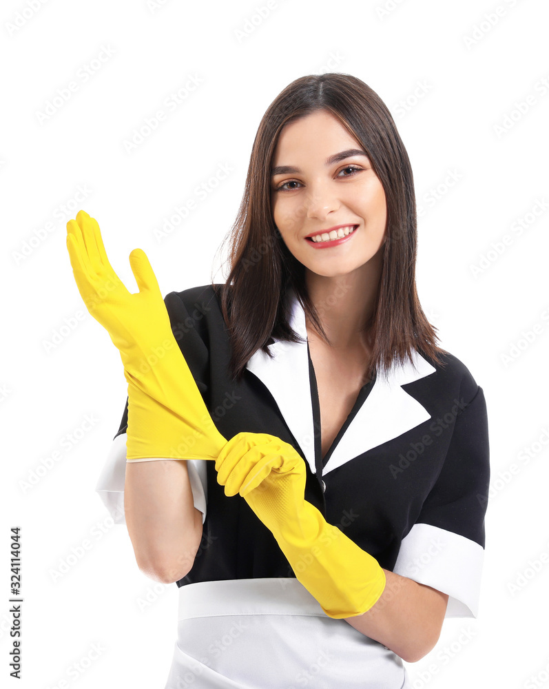 Portrait of beautiful chambermaid putting on rubber gloves against white background