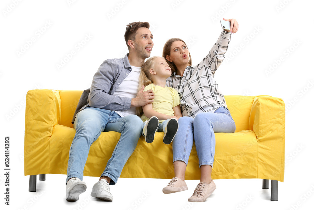 Happy young family taking selfie on sofa against white background