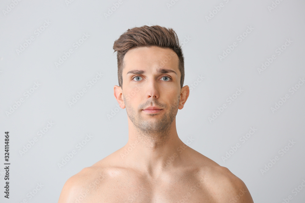 Handsome young man on light background. Plastic surgery concept