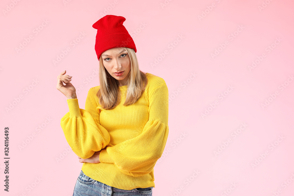 Young woman in warm sweater on color background