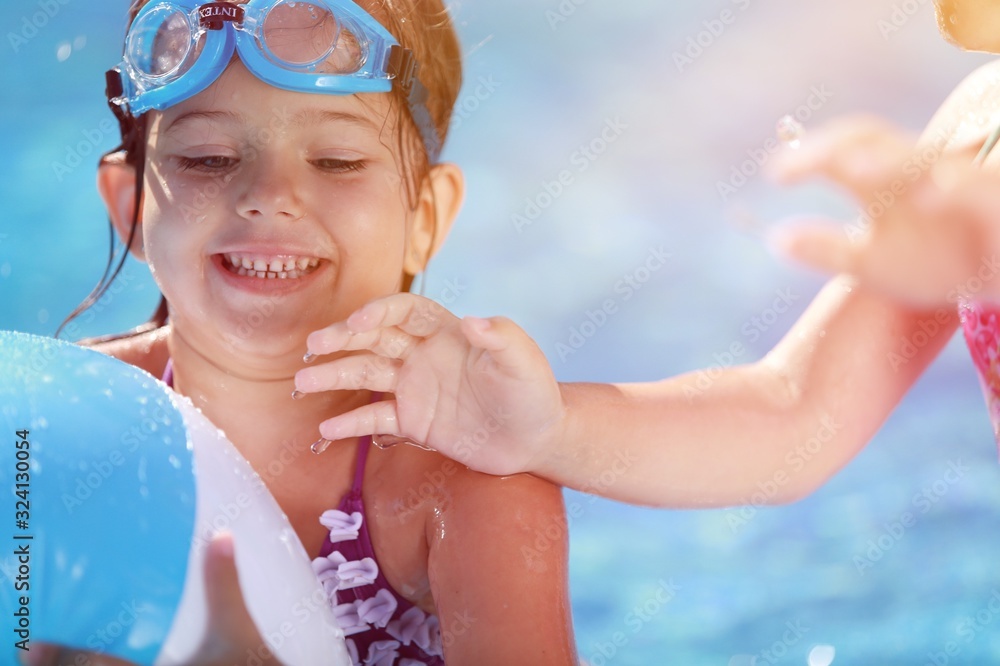 Beautiful girl playing at the swimming pool