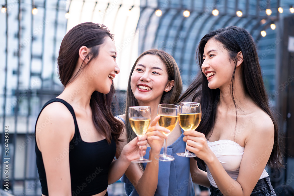 Group of young cute Asian girl gang best friends having party at rooftop restaurant. Girls drinking 