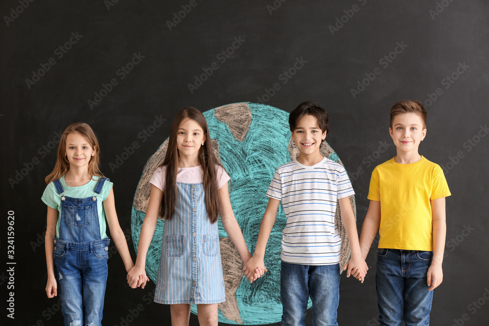 Little children and drawing of planet on dark background. Earth Day celebration