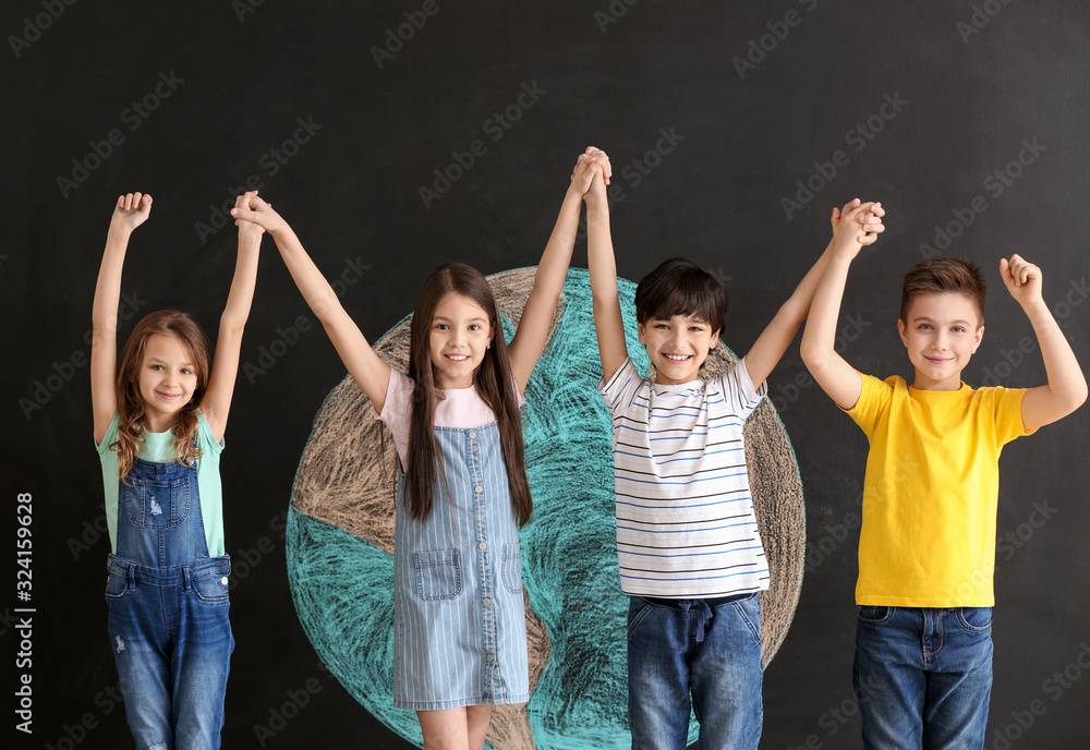 Little children and drawing of planet on dark background. Earth Day celebration