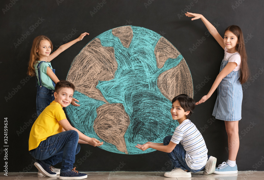 Little children and drawing of planet on dark background. Earth Day celebration