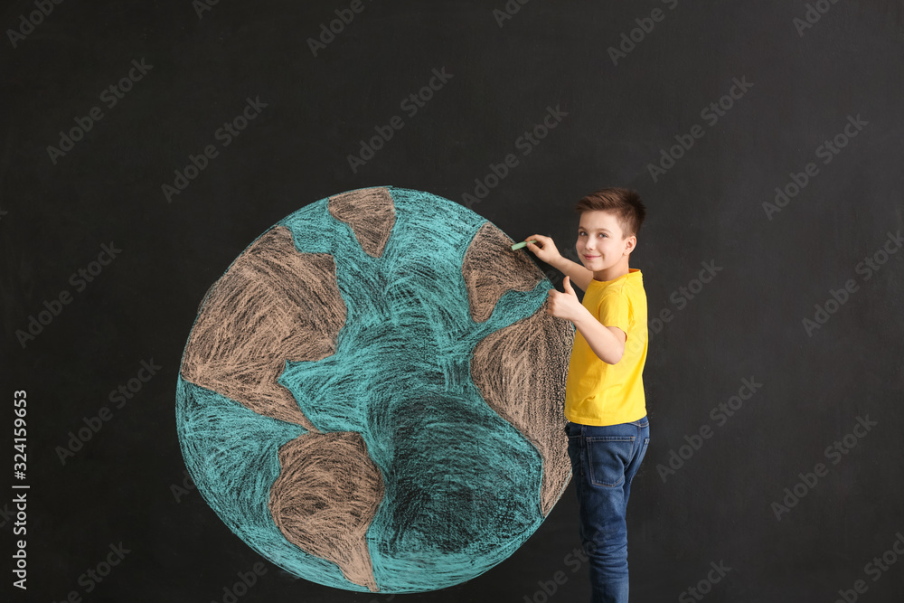 Little boy drawing planet on dark background. Earth Day celebration