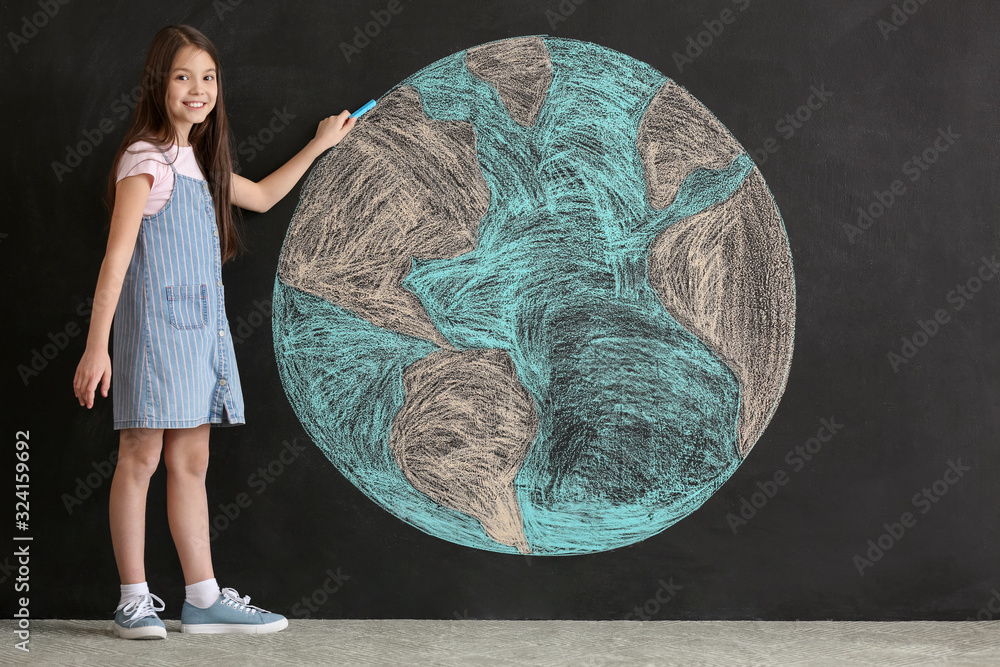 Little girl drawing planet on dark background. Earth Day celebration