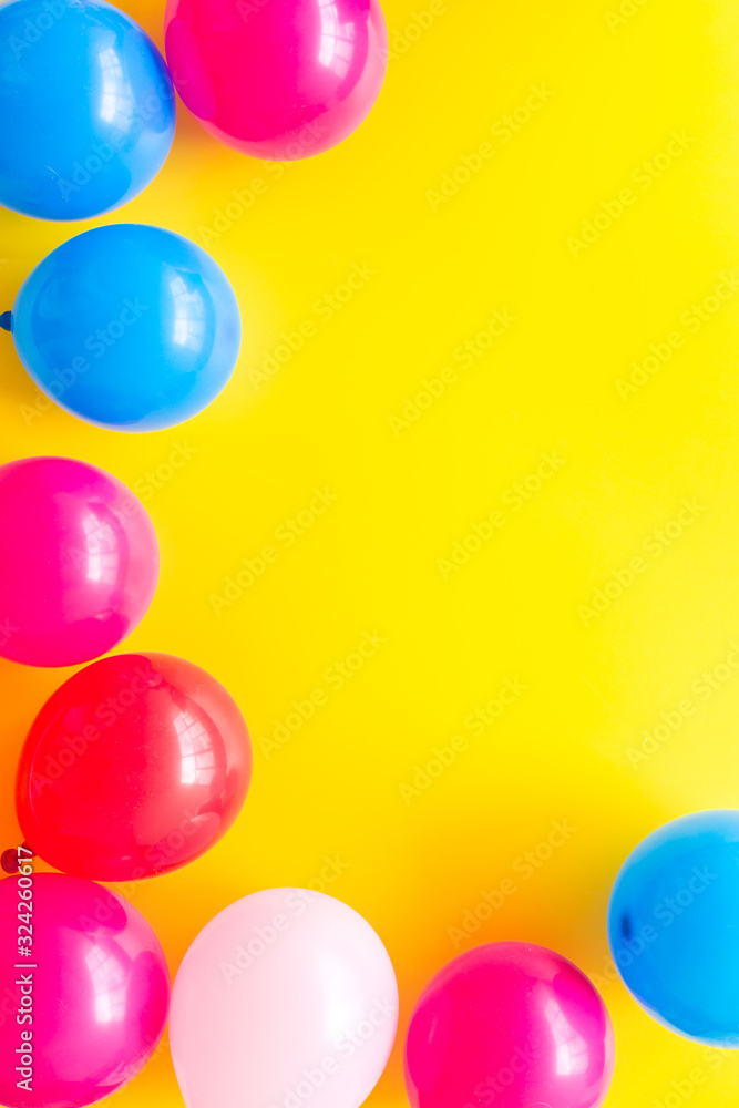 Colorful balloons frame on yellow background top-down frame copy space