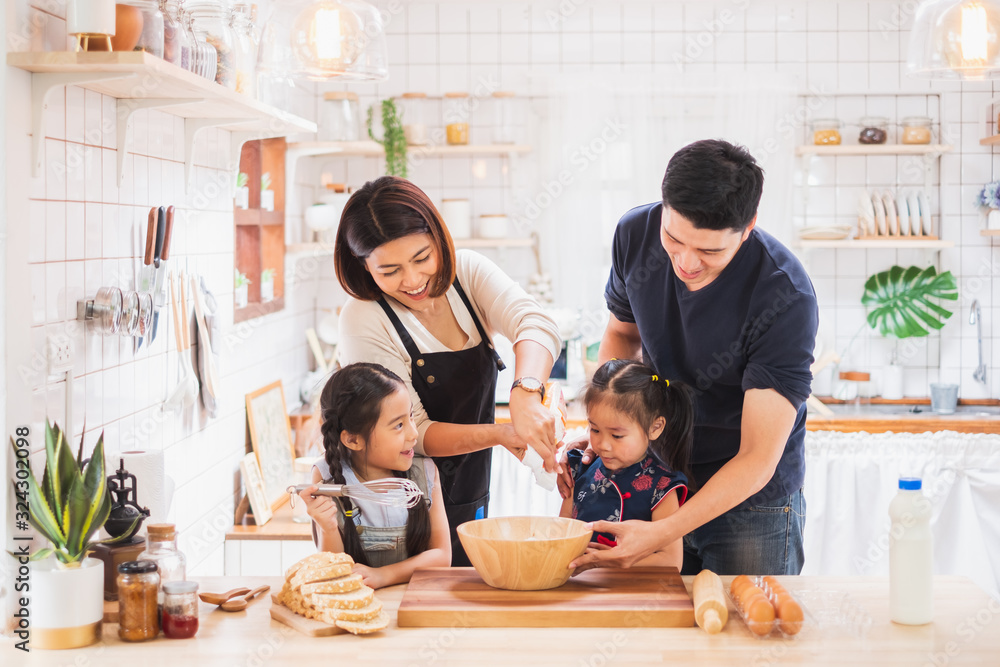 Asian family enjoy playing and cooking food in kitchen at home