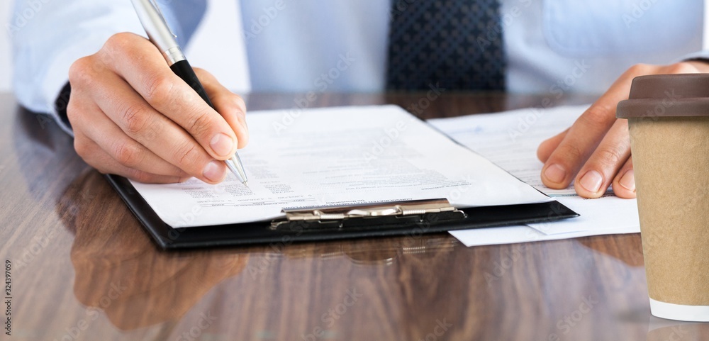 Businessman hands writing in a notebook on office desk