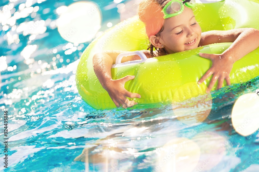 Beautiful girl playing at the swimming pool