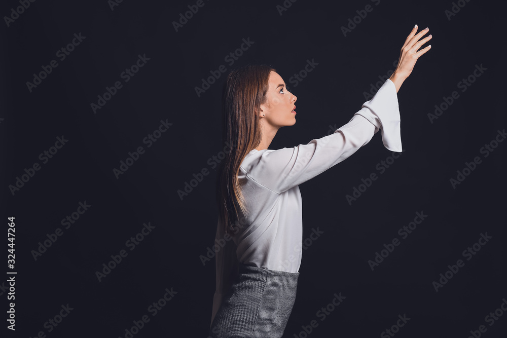 Businesswoman pointing at something on dark background. Concept of choice