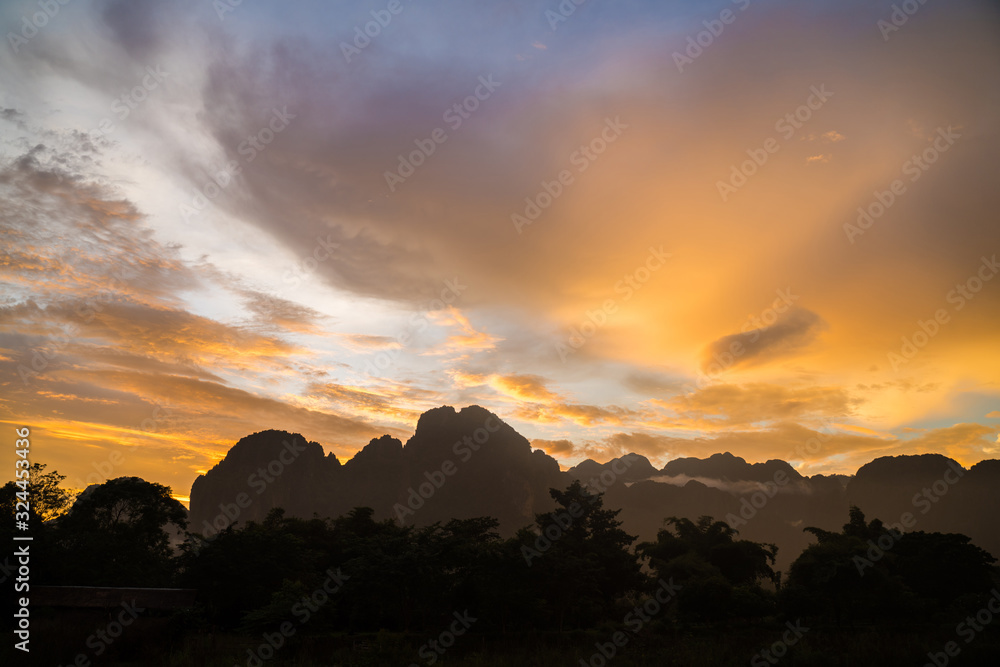 Silhouette of hills by the river at sunset. Stunning twilight sky at blue hours