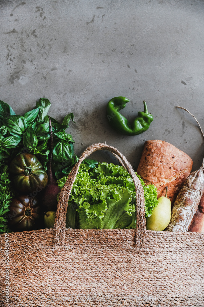 Flat-lay of healthy grocery shopping eco-friendly bag with vegetables, fruit, greens, bread and saus