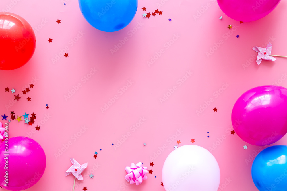 Party concept. Colorful balloons and confetti on pink background top-down frame copy space