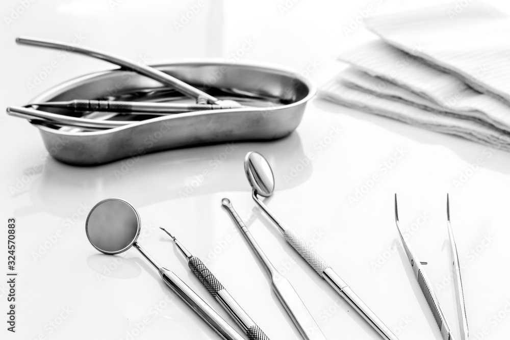 Dental instruments in stainless steel tray on white background close up