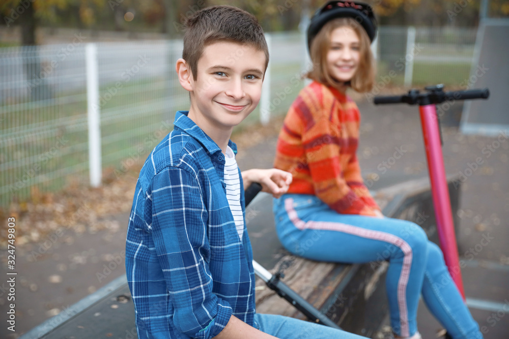 Active teenagers with kick scooters outdoors