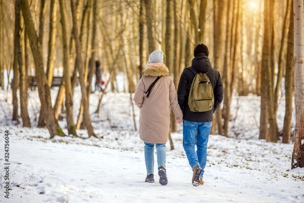 A guy and a girl walking in winter Park