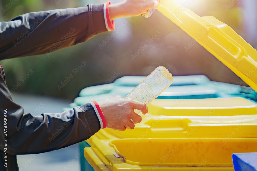 hand holding garbage bottle plastic putting into trash for cleaning