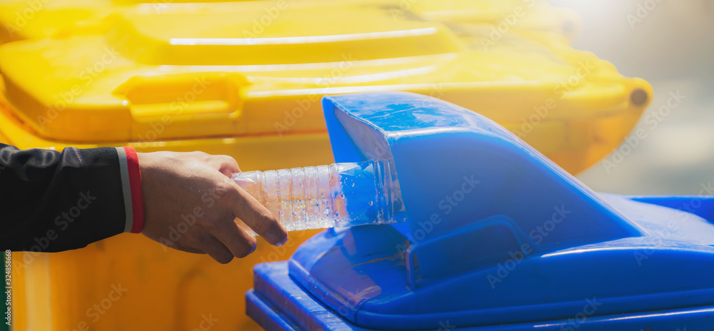 hand holding garbage bottle plastic putting into trash for cleaning