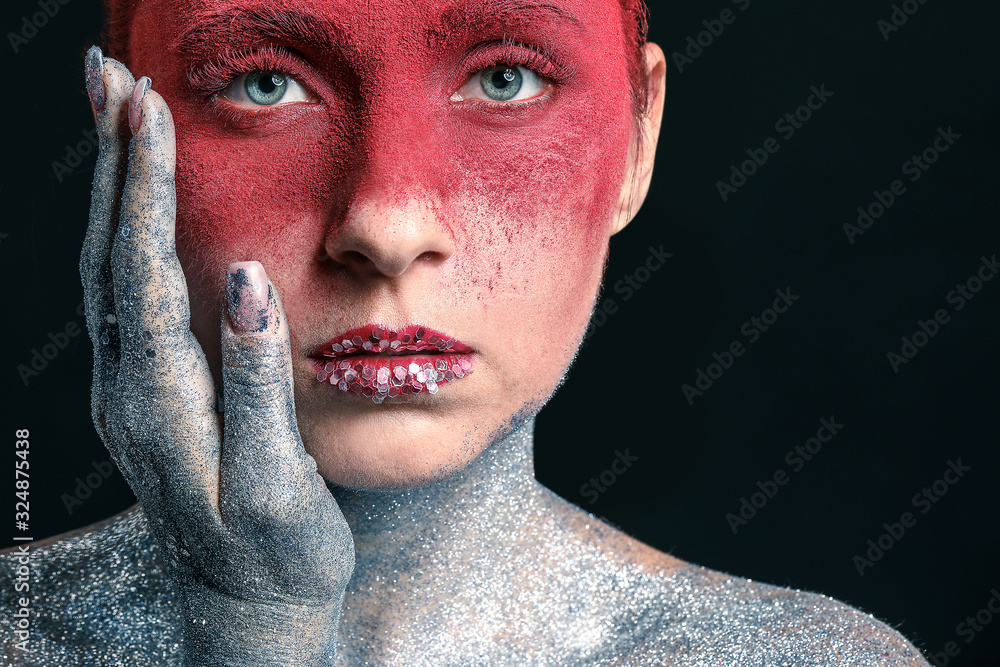 Beautiful woman with unusual makeup on dark background