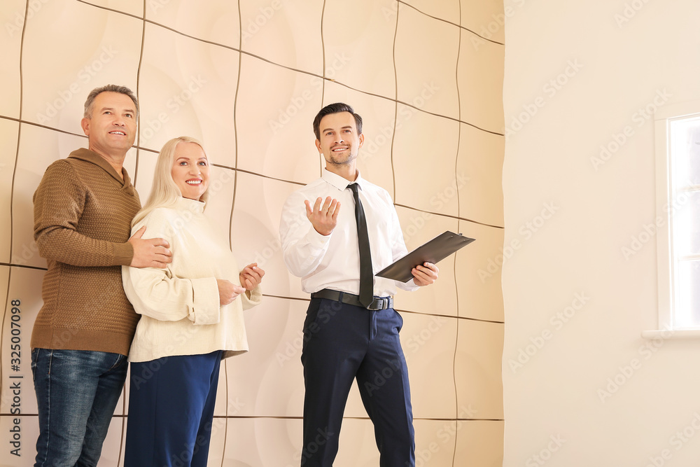 Male real estate agent showing mature couple a new house