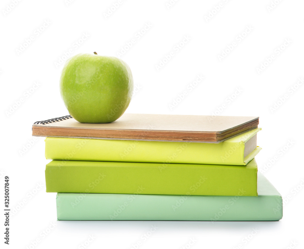 School books and apple on white background