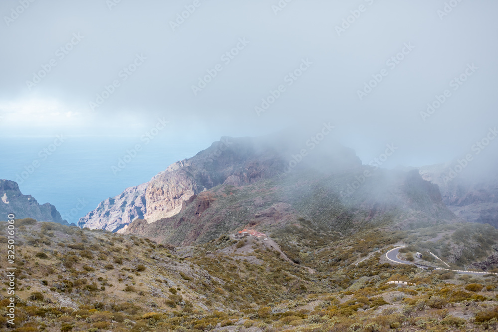 Beautiful landscape on a rocky mountain with the ocean on the background under the clouds, Tenerife 