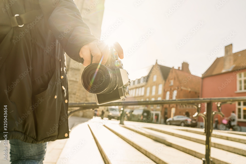 特写亚洲女性手持复古相机旅行者，背景为古老的传统建筑，a