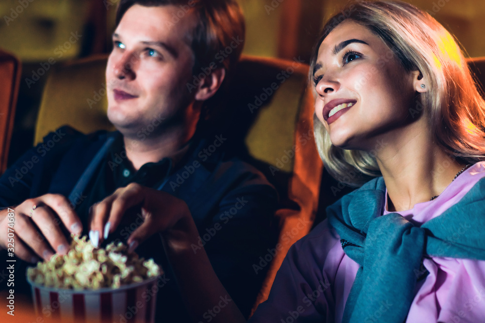 Caucasian lover enjoying to watch movie and eating popcorn together in the cinema