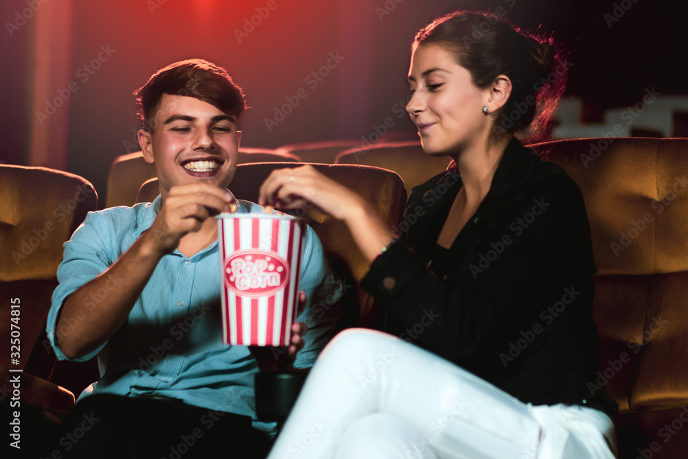 Man and woman watching movie in the movie theater cinema. Group recreation activity and entertainmen