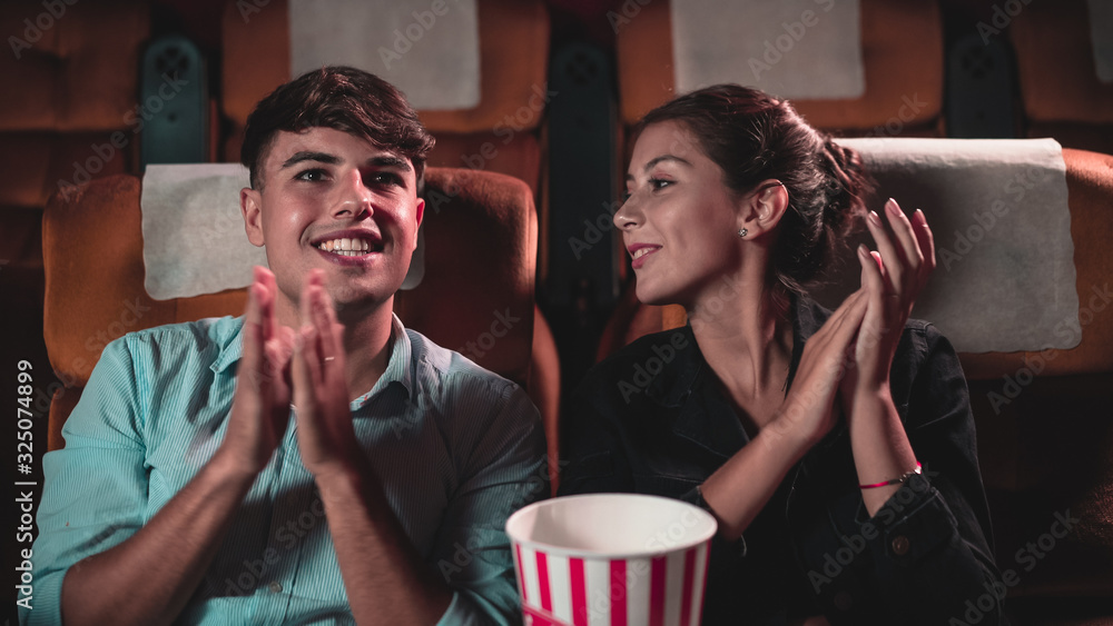 Man and woman applauding enthusiastically at the end of a performance and walk away