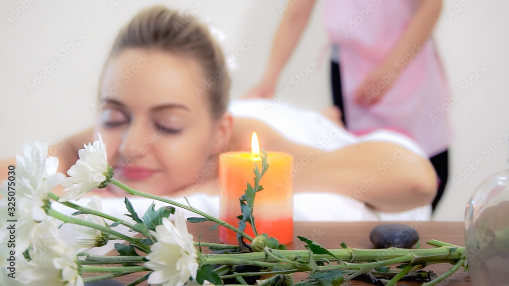 Relaxed woman getting back massage in luxury spa with professional massage therapist. Wellness, heal