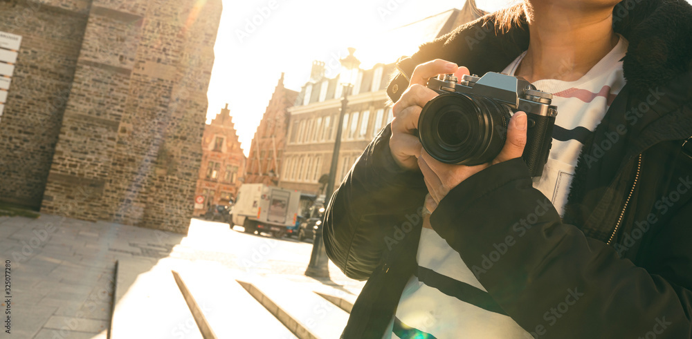 特写亚洲女性手持复古相机旅行者，背景为古老的传统建筑，a