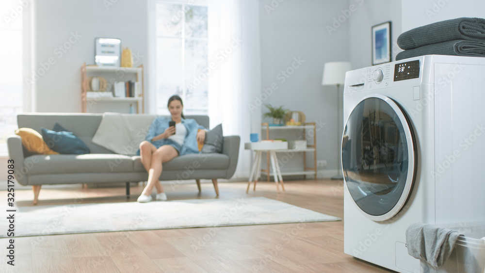 Shot of a Modern Technologically Advanced Washing Machine Working in a Bright and Spacious Living Ro