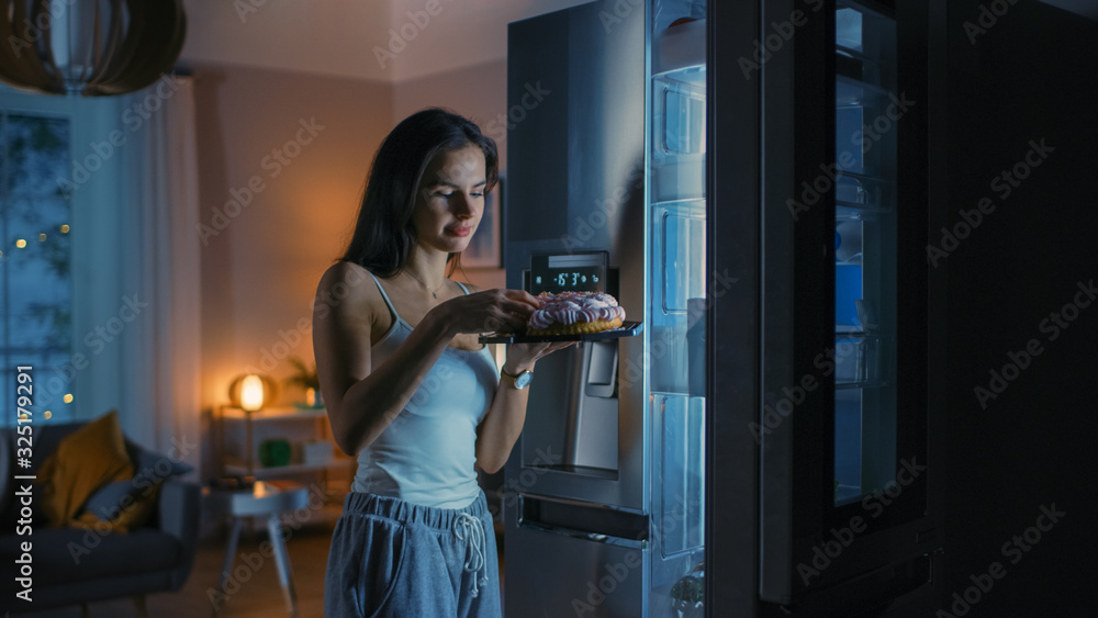 Hungry Beautiful Young Woman in the Kitchen in the Evening Opened the Fridge, Takes out a Piece of a