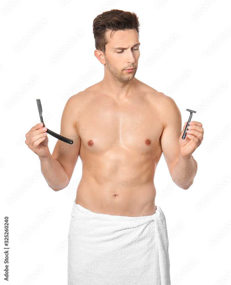 Handsome young man with different razors on white background