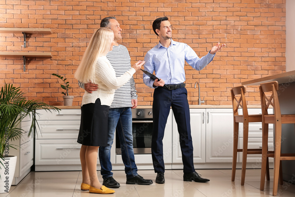 Male real estate agent showing mature couple a new house