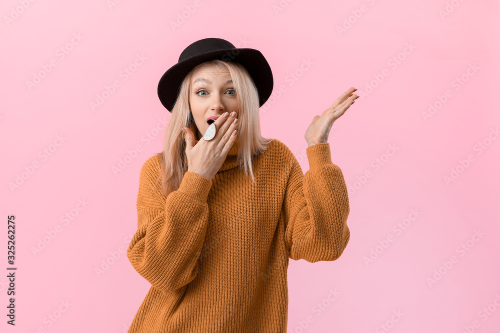 Surprised woman in warm sweater on color background