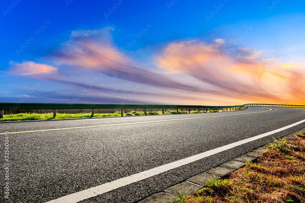 Empty asphalt road and beautiful colorful clouds landscape at sunset.