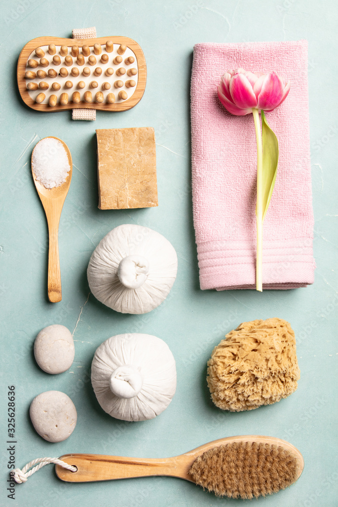 Flat lay of spa treatment set with pink flowers