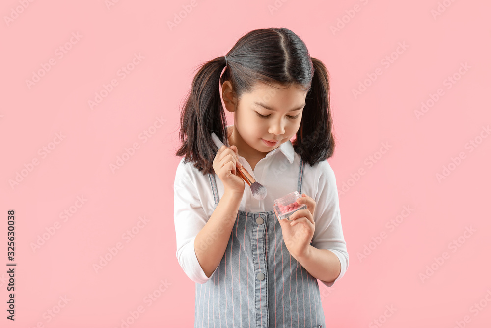 Cute little makeup artist on color background